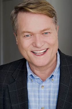 Jim Dykes smiling in a blue shirt and suit coat